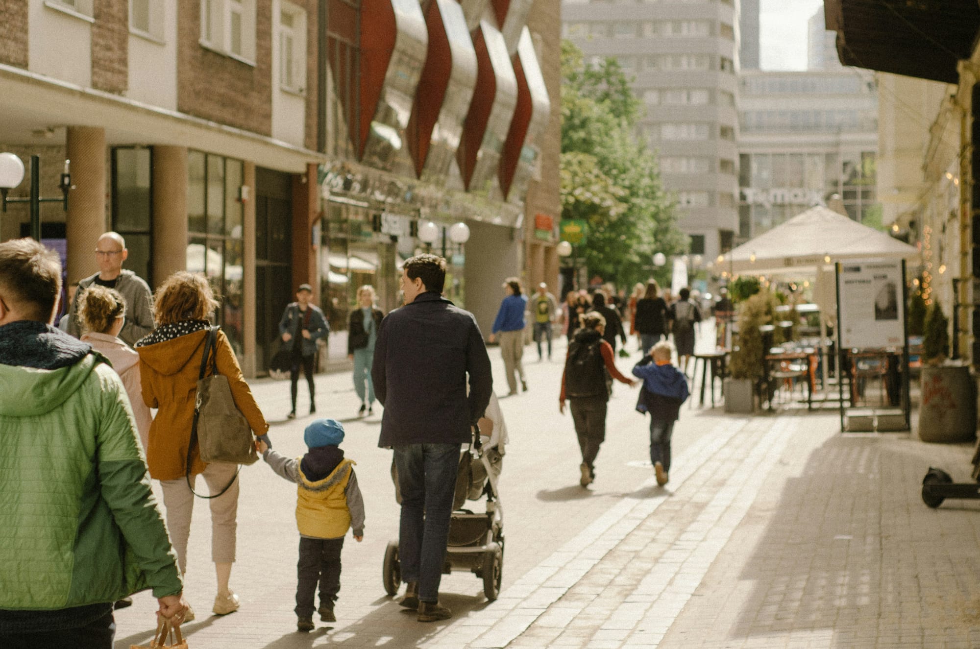 A photo of a street busy with pedestrians of all ages.